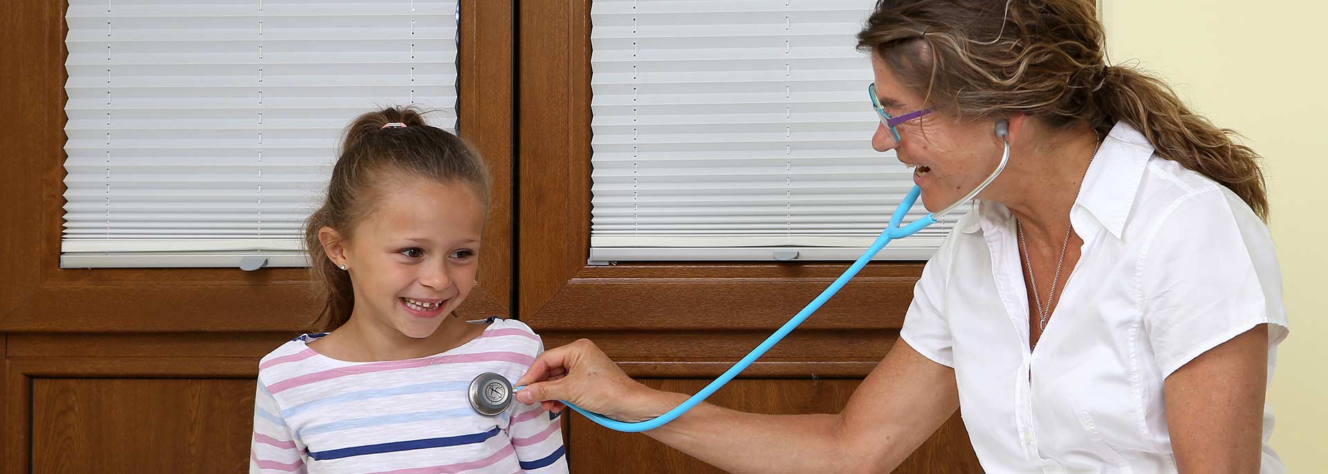 Ärztin hört Kind mit Stethoskop ab 
